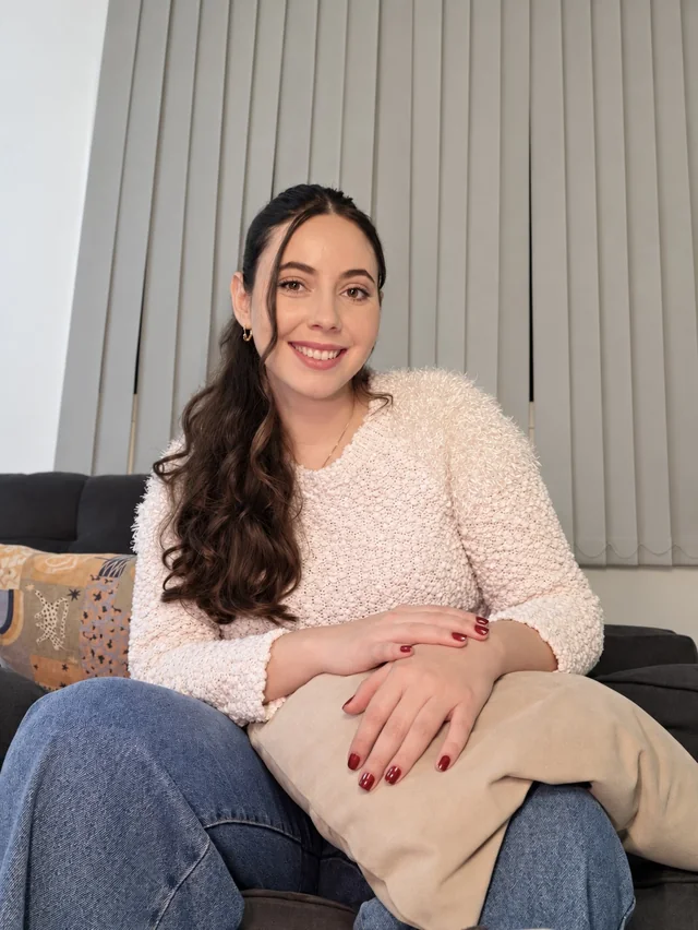 Jheniffer Lorraine sentada em um sofá